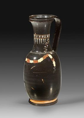 Very rare olpe of the Gnathia Ware. 4th century BC. Height 19,5cm, &oslash; corpus 8,7cm. Black glazed 