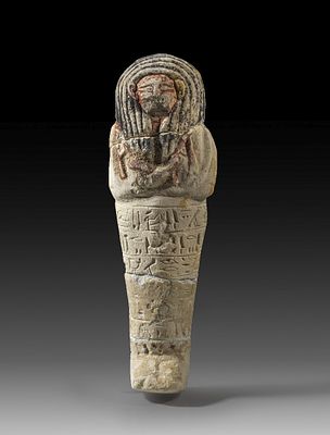 Shabti of limestone. Shabti of limestone with remains of the painting, H 29cm (without wooden 