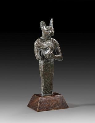 Bronze statuette of standing Bastet. Bronze statuette of standing Bastet holding a lion-headed 