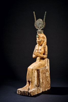 Gilded statuette of enthroned Isis. Wood with stucco. H 34cm. Isis sits on a throne with a low 