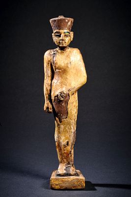 A wooden figure of Min-Amun. Gilded. New Kingdom, 1570 - 1069 BC. The god is wearing the cap of 