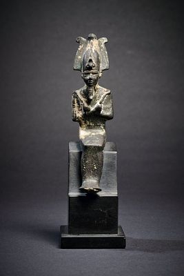 Bronze statuette of the god Osiris. H 11,6cm. Mummy-shaped figure sitting with a ceremonial 