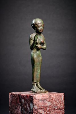 Praying woman. A bronze figure of a praying woman wearing a long tunic and raising her right 