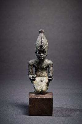 Kneeling king. A bronze figure of a kneeling pharao holding two nw-mild-pots and wearing the 