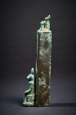 Votive pillar with cats. A votive bronze pillar with three cats sitting on top and a cat 