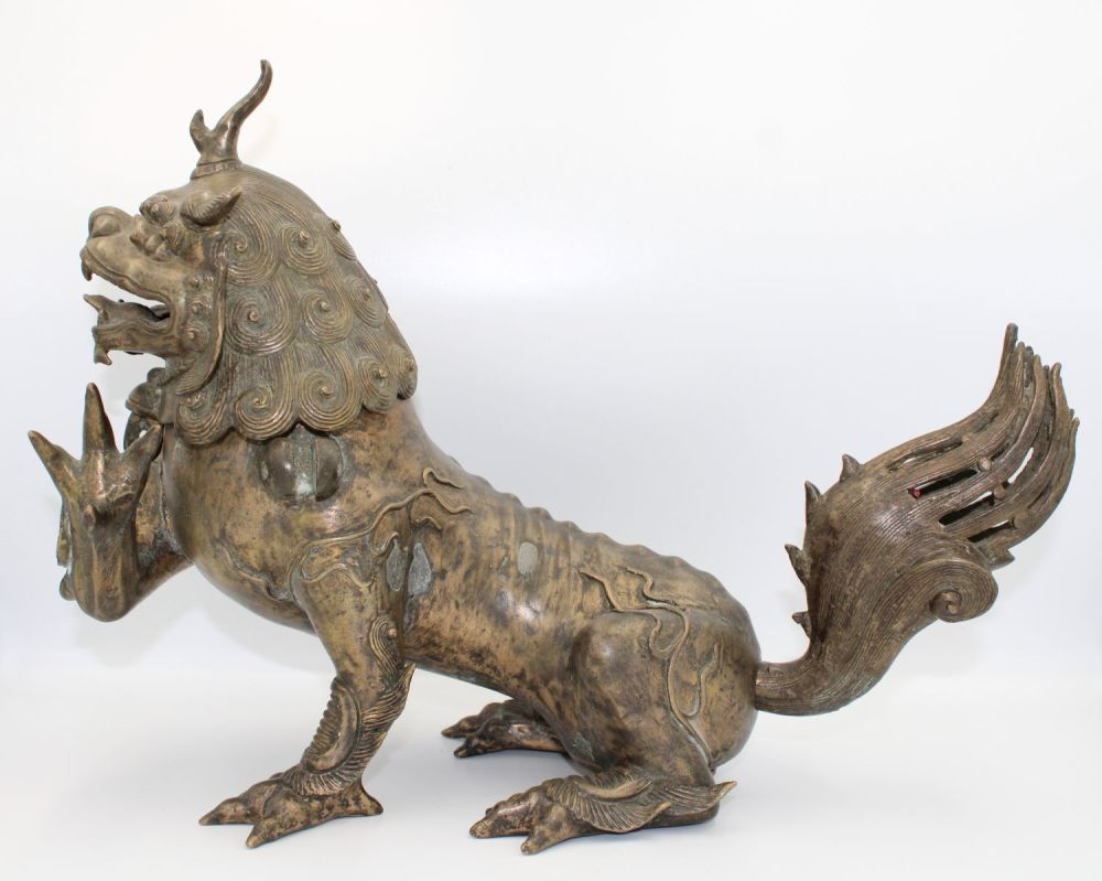 Lot 60: 18th-century Chinese bronze Buddhist lion featuring intricate craftsmanship....
