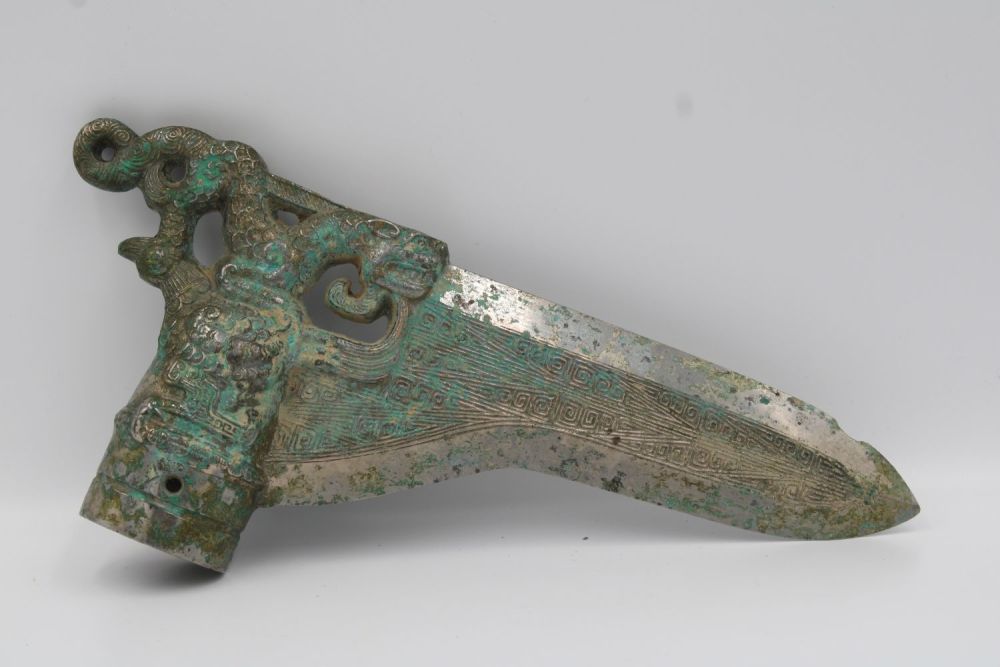 Lot 67: Shang Bronze dagger with dragon and phoenix decoration.