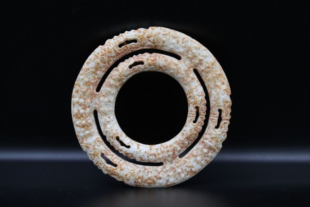 Lot 72: Two Chinese conjoined jade russet rings depicting dragons.