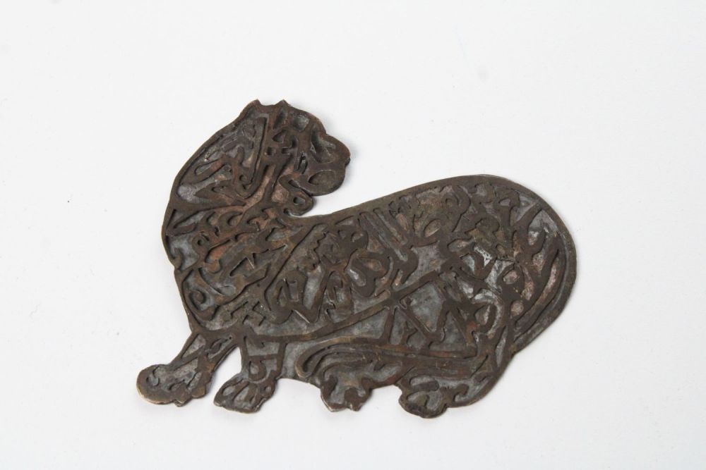 Lot 125: Islamic Bronze Lion with Engraved Calligraphy: This striking...