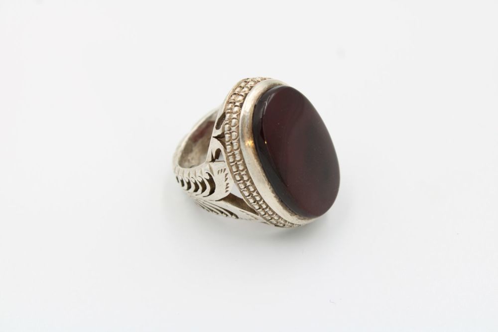 Lot 196: A men's silver ring showcasing a rich, dark...