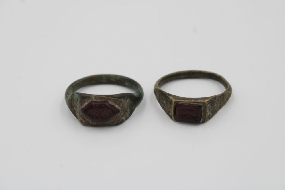 Lot 199: Pair of antique bronze rings featuring garnet stones.