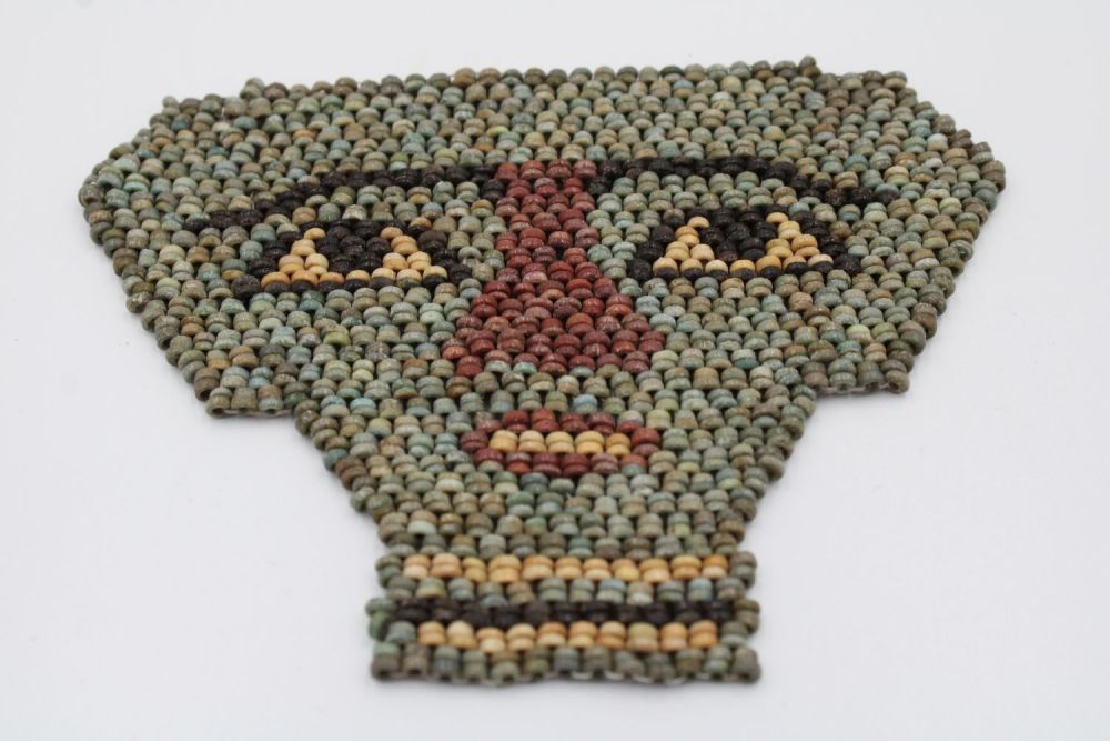 Lot 204: Double-sided Egyptian beaded face art piece.
