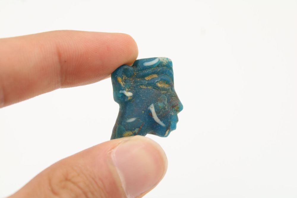 Lot 223: Ancient Egyptian Ptolemaic green/blue glass face inlay, dating...