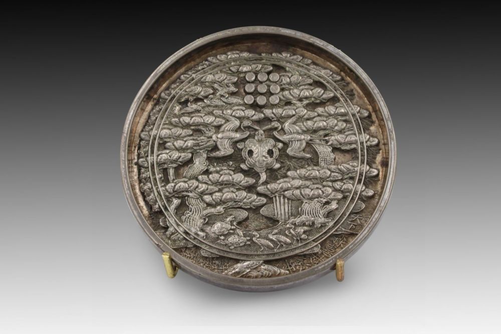 Lot 259: A Japanese Bronze Mirror with a Silver Design...