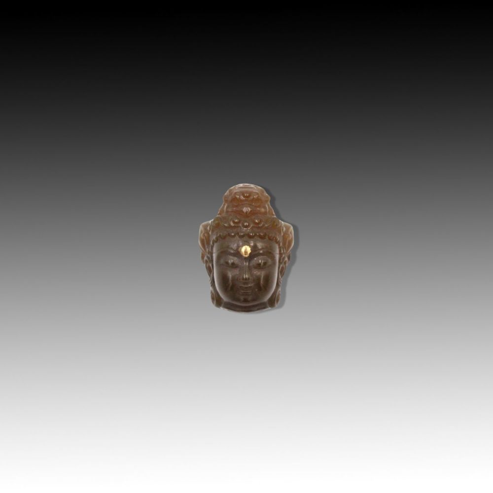 Lot 273: A Possible Tibetan Buddha head pendant, in brown...