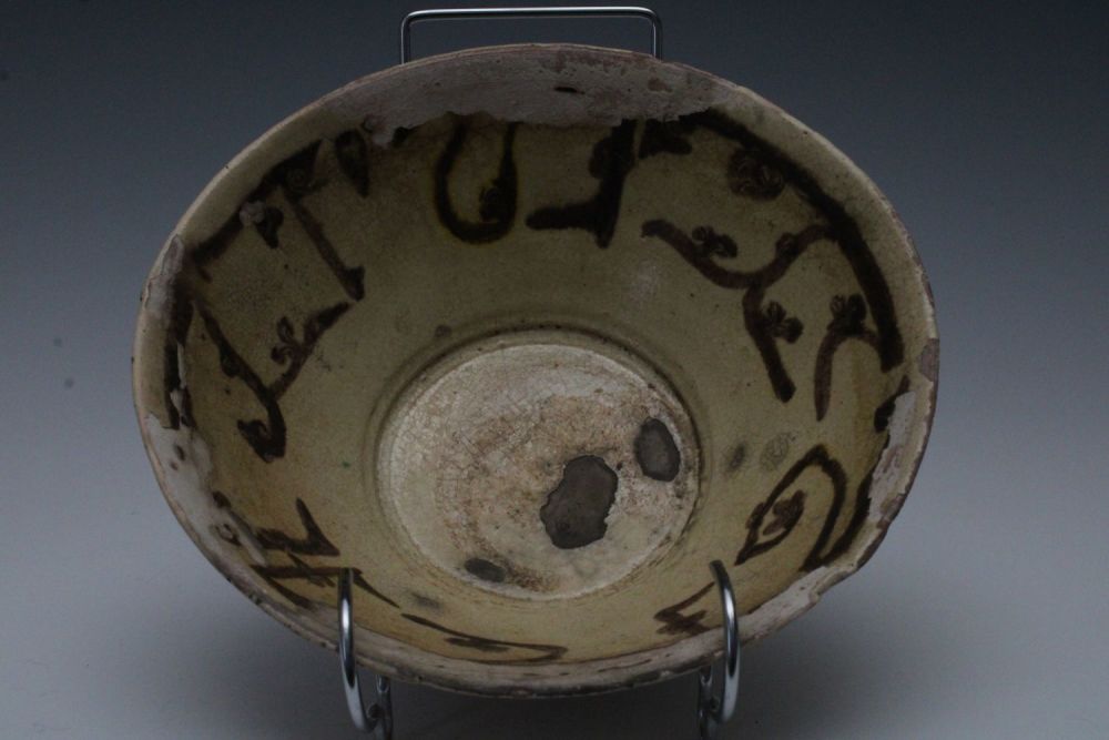 Lot 39: An Islamic Yellow Glazed Dish with Kufic Inscriptions.