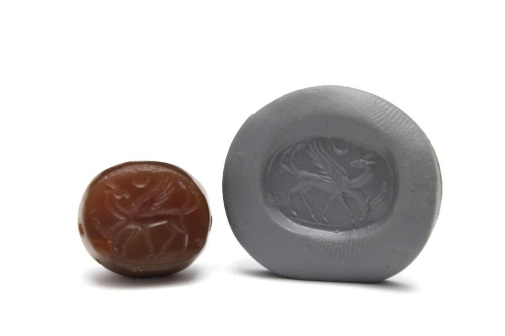 Lot 434: A Greco-Persian Dark Red Agate Scarab Depicting Two...