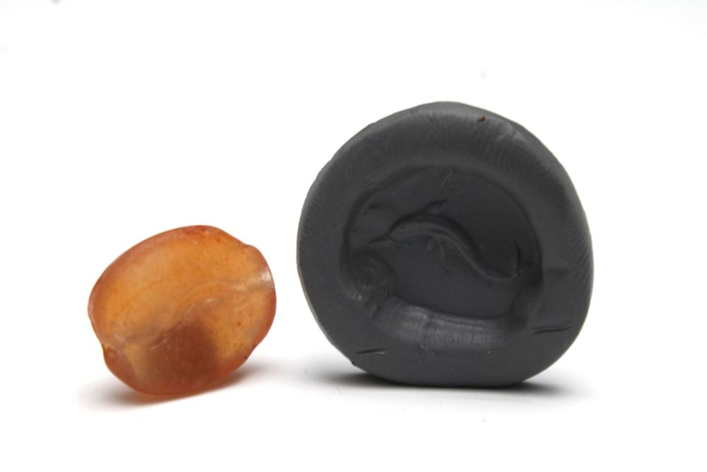 Lot 435: A Greek Carnelian Scarab Gem Depicting a Dolphin.