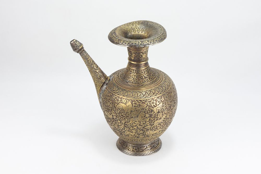 Lot 167: An Islamic Persian Brass Water Jug with intricate...
