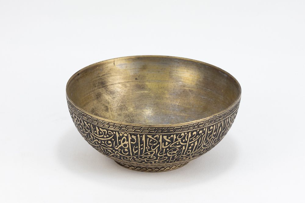 Lot 170: An Islamic Persian Brass Bowl with Intricate Carvings...