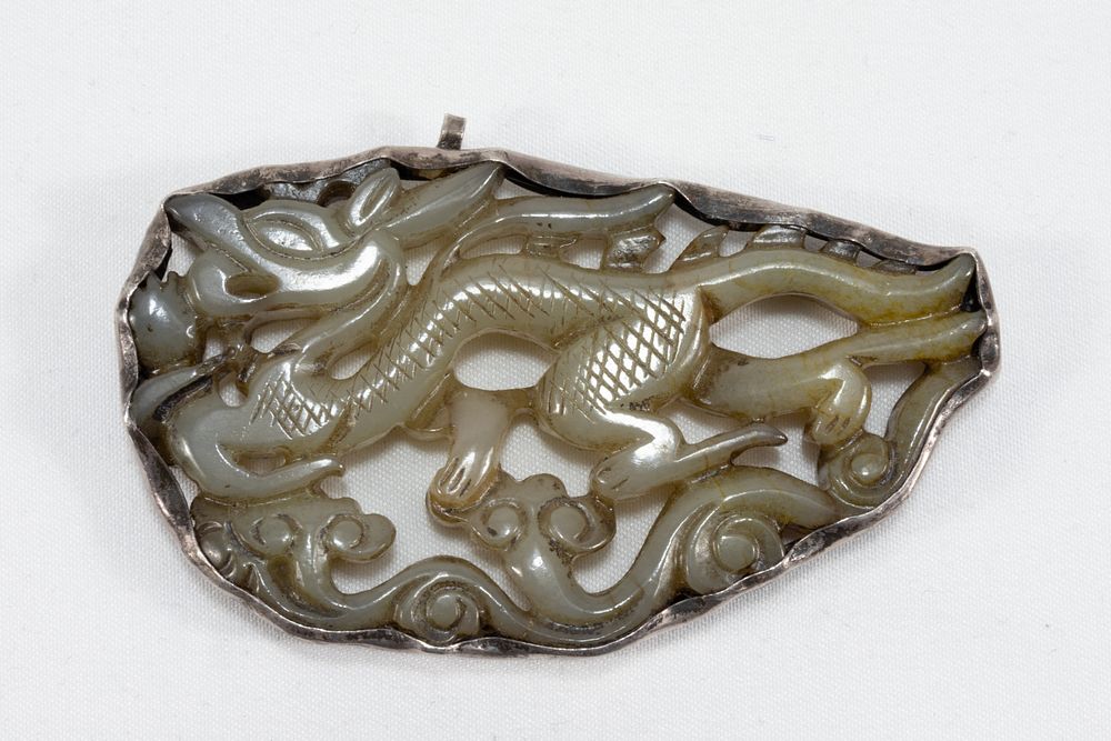 Lot 107: A Chinese Carved Jade & Silver Pendant.