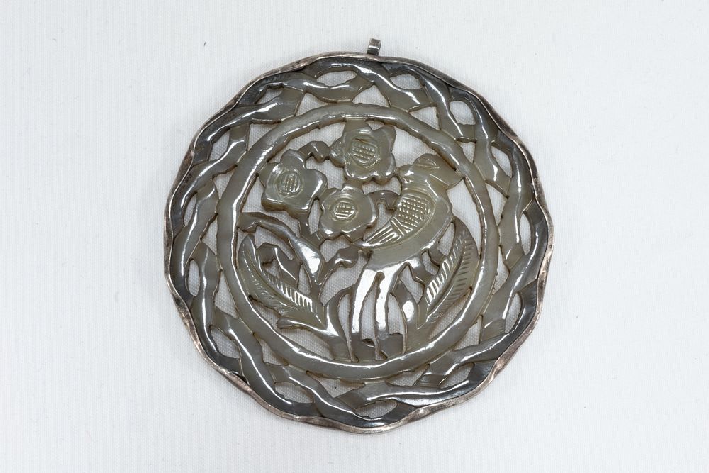 Lot 110: A Chinese Carved Jade & Silver Round Pendant.