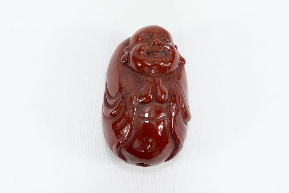 Lot 111: A Chinese Red Agate Lucky Buddha Pendant.