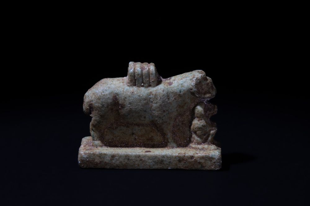 Lot 186: An Egyptian Faience Ram Amulet with a Seated...