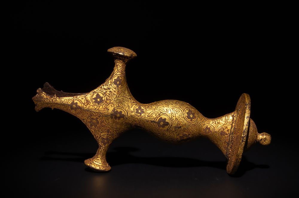 Lot 171: An Indian Mughal Gold Damascened Iron Sword Handle.