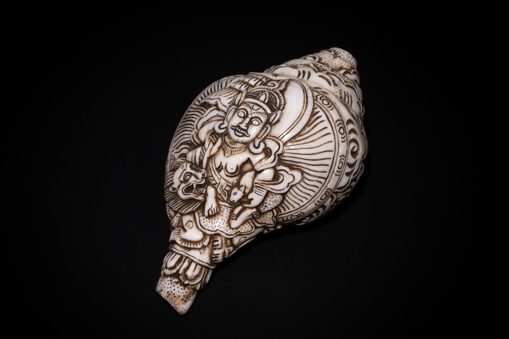 Lot 215: A Tibetan Carved Sea Shell with Deity Motif.