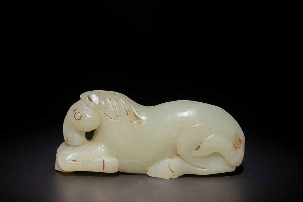 Lot 253: A Chinese Carved Pale Green Jade Reclining Horse.