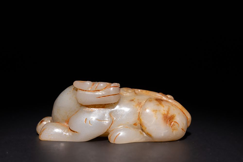 Lot 254: A Chinese Carved Green and Russet Jade Creature,...
