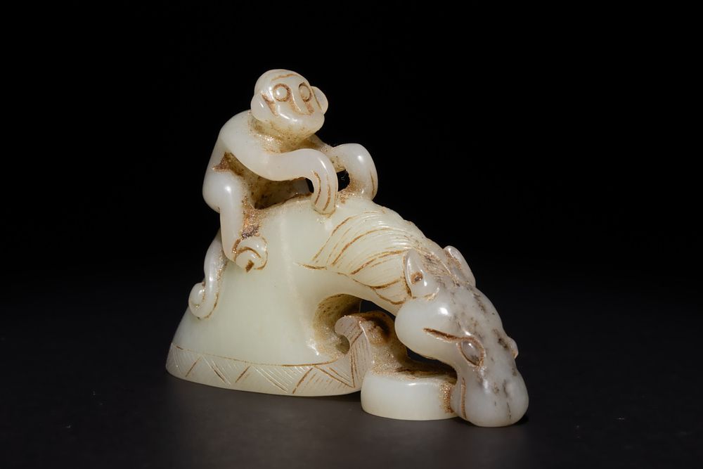 Lot 255: A Chinese Green and Russet Jade Carving of...