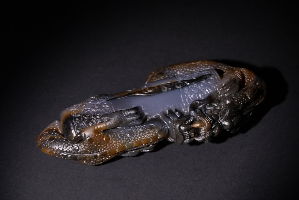 Lot 157: A Chinese Agate Pendant with Carved Dragon Motif.