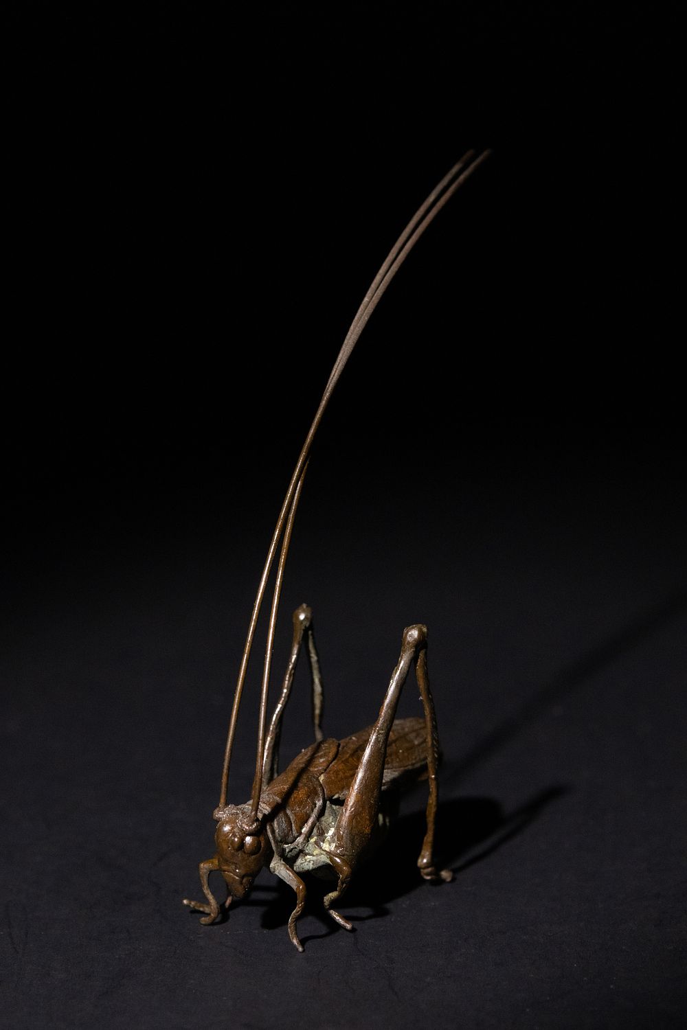 Lot 188: A Japanese Bronze Cricket Figurine with Extended Antennae.