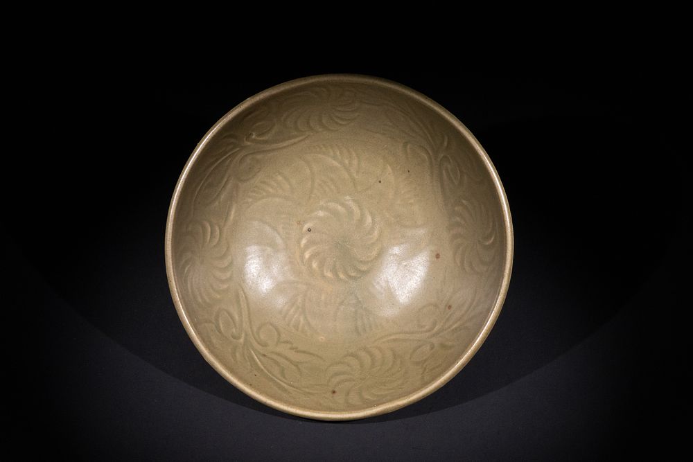 Lot 289: A Chinese Celadon-Glazed Bowl with Incised Floral Motifs.