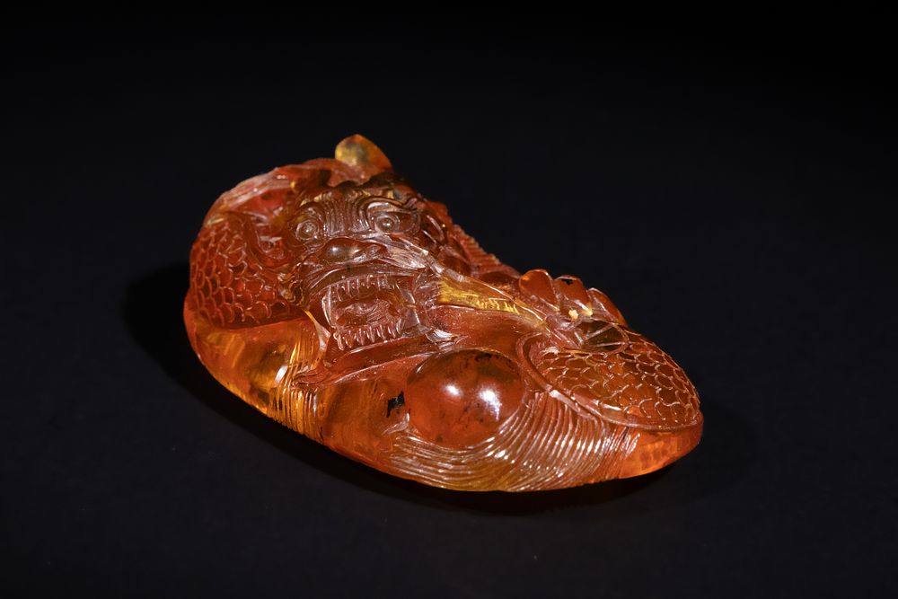 Lot 318: A Chinese Amber Carving of a Dragon with...