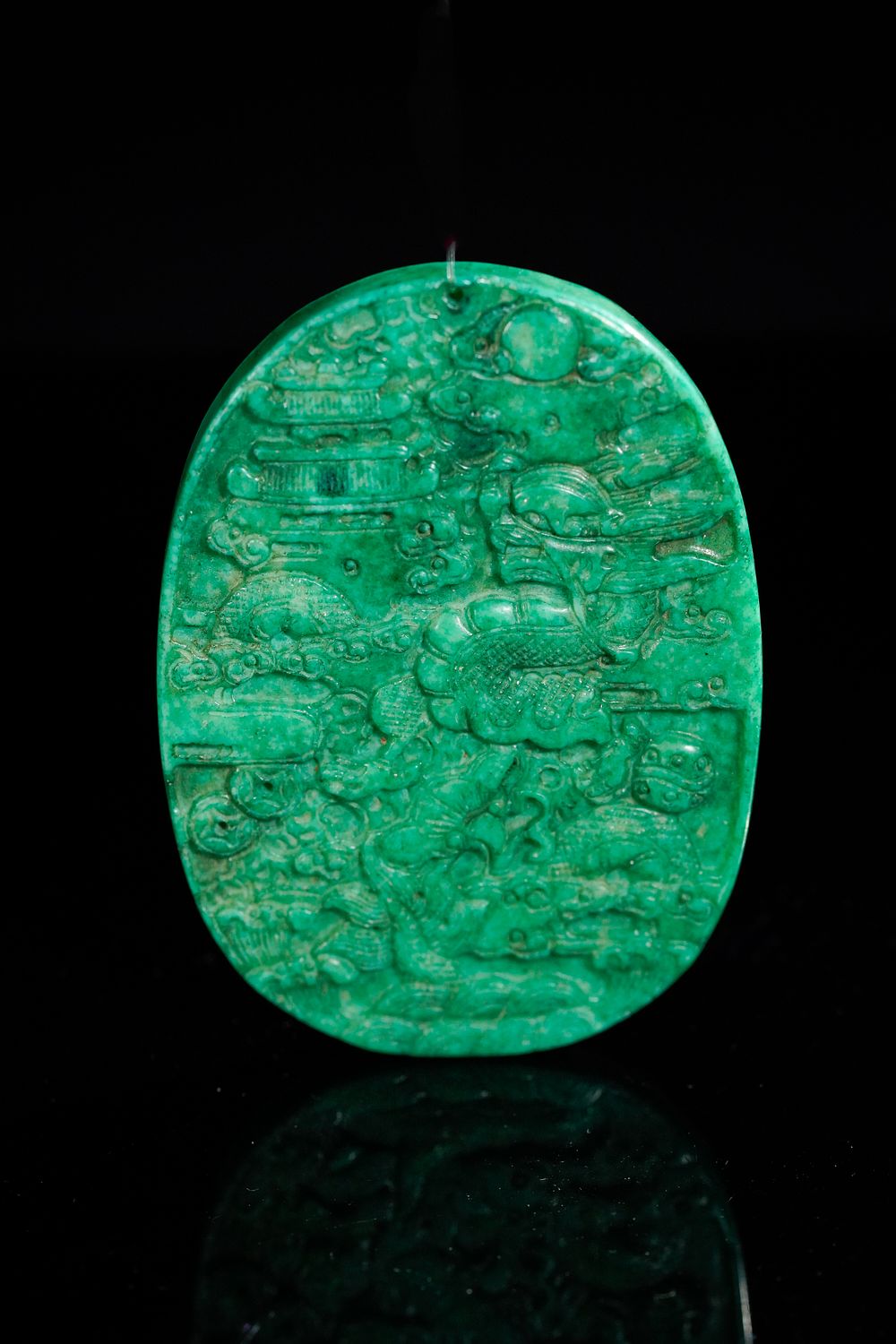 Lot 342: A Chinese Green Jade Pendant with Celestial Motifs.