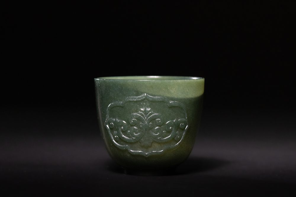 Lot 201: A Mughal Green Jade Cup with Relief Scrollwork,...