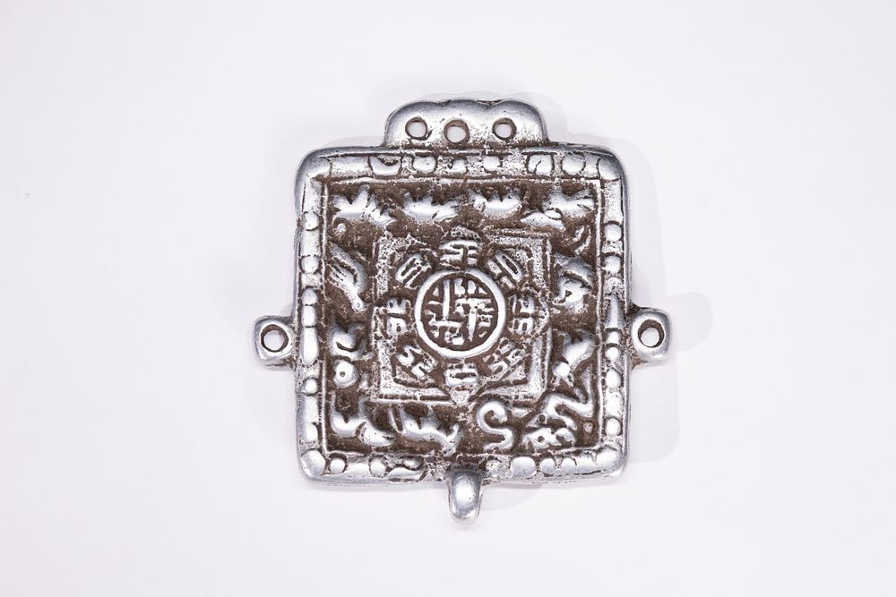 Lot 244: A Chinese Tibetan White Metal 'Nine Palace' Amulet...