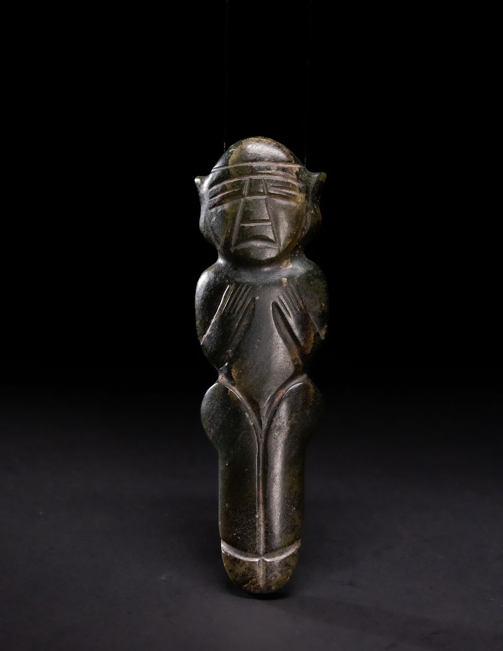 Lot 258: A Carved Dark Jade Idol with Stylised Facial...