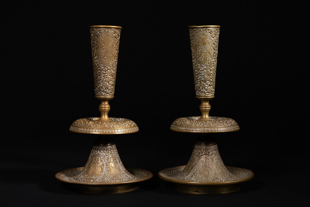 Lot 172: A Pair of Indo-Persian Engraved Brass Candle Holders...