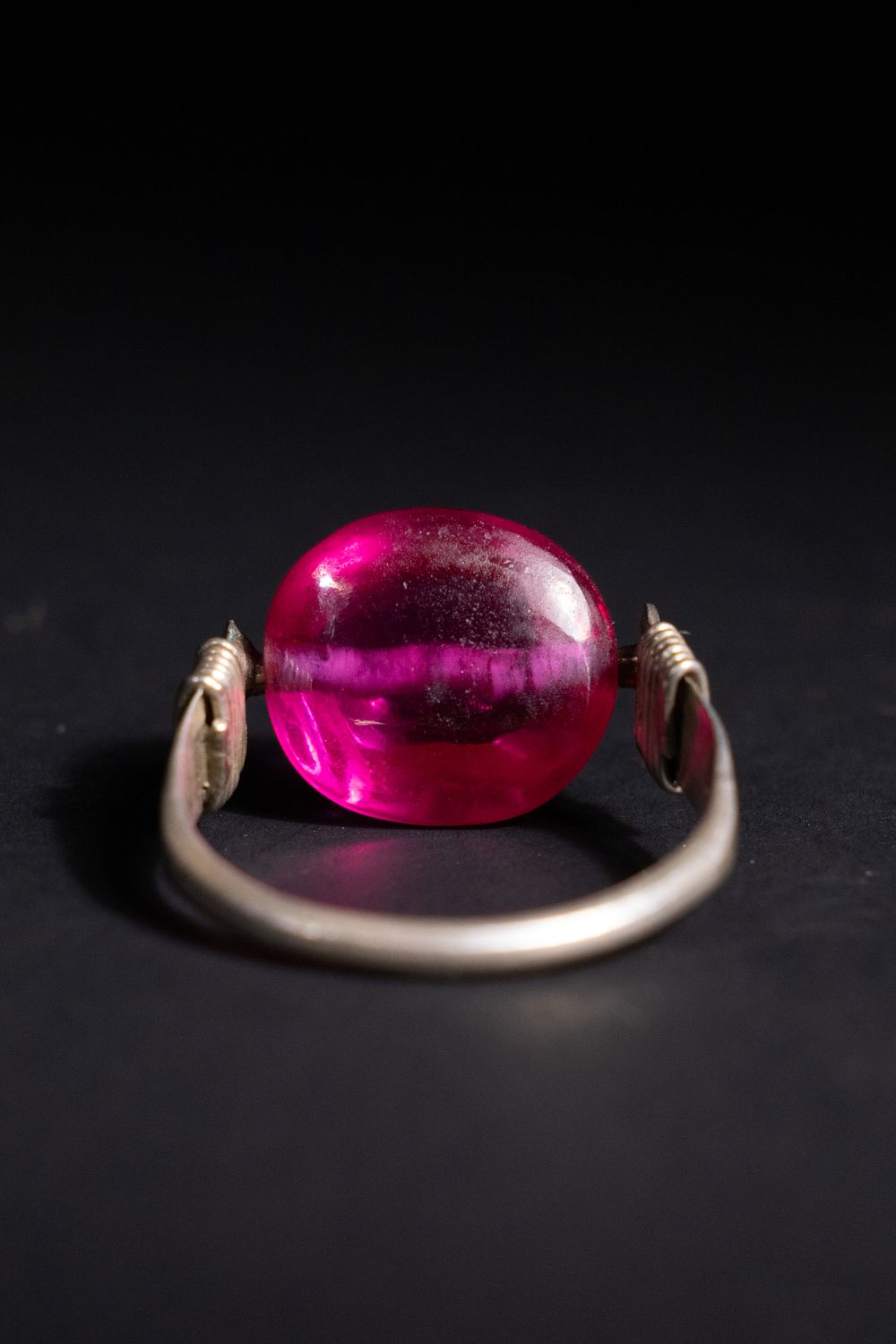 Lot 180: An Indian Silver Ring with Pink Glass Bead.