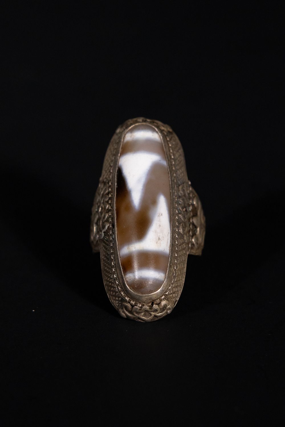 Lot 219: A Tibetan Silver Dzi Bead Ring.