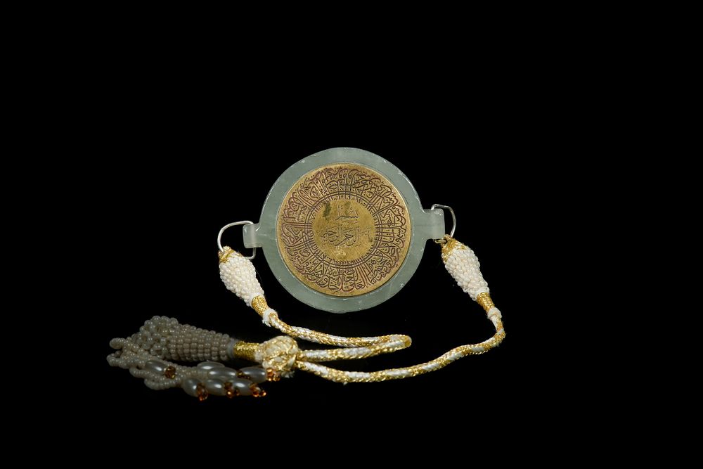 Lot 160: An Islamic Jade and Brass Talismanic Bazuband.