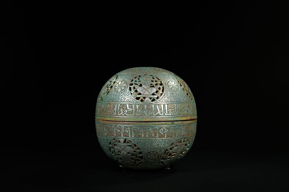 Lot 164: An Islamic Brass Silver-Inlaid Spherical Lidded Box.