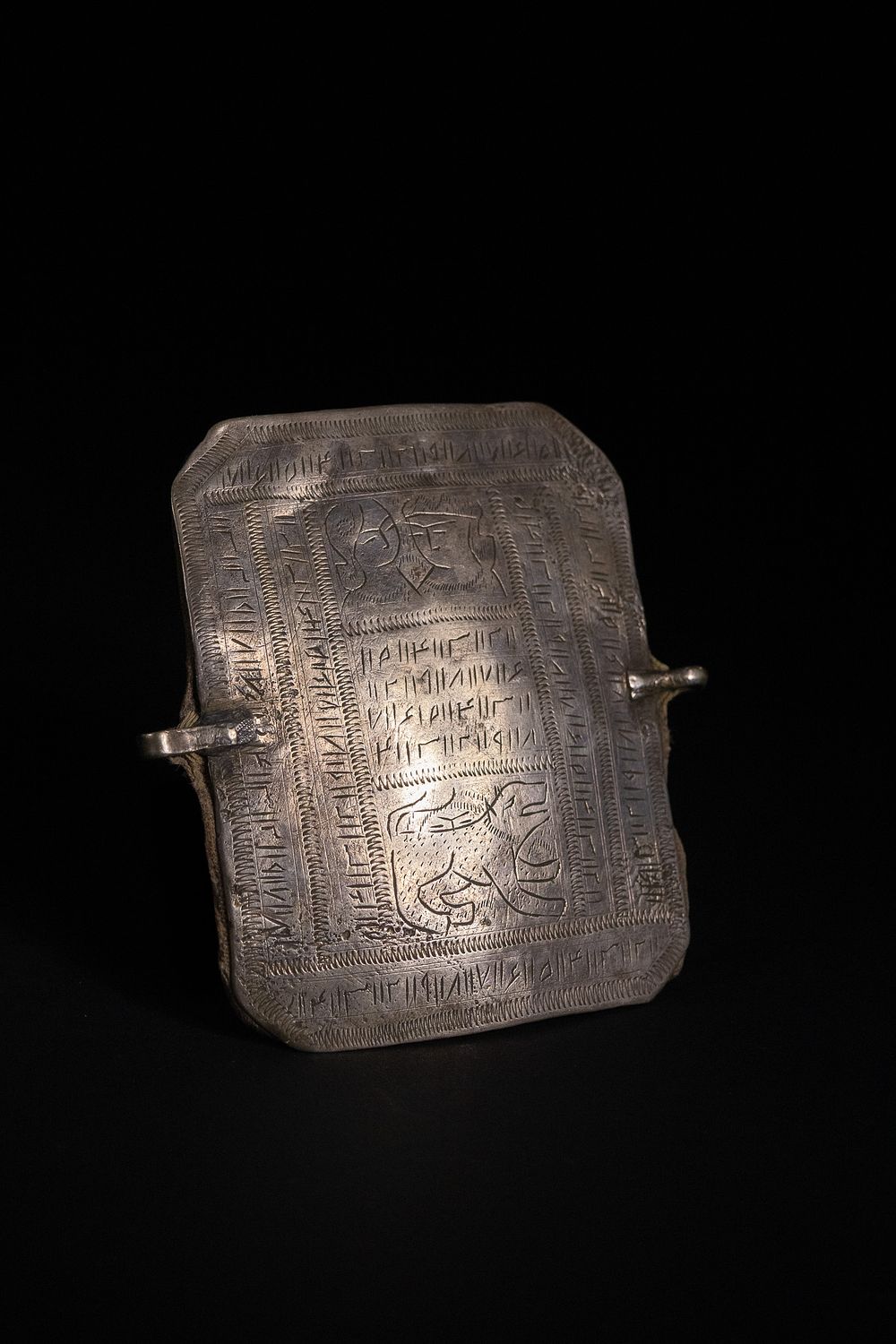 Lot 168: An Islamic Silver Bazuband with Engraved Calligraphic Panels.