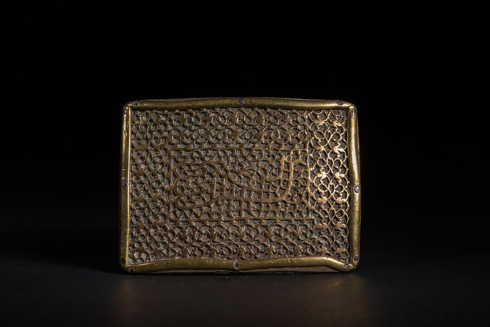 Lot 170: An Islamic Brass Openwork Bazuband with Calligraphic Cartouche.