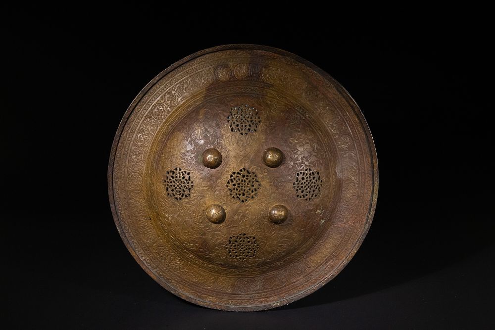 Lot 176: A Qajar Copper-Brass Shield with Openwork Panels, 19th...