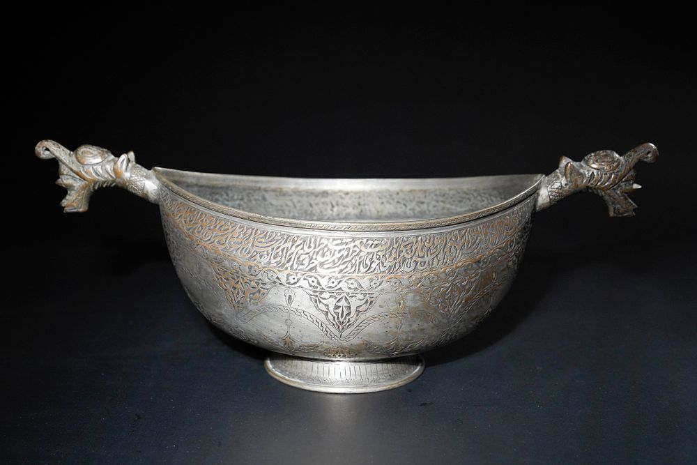 Lot 220: A Qajar Copper Kashkul Beggar's Bowl with Dragon-Head...
